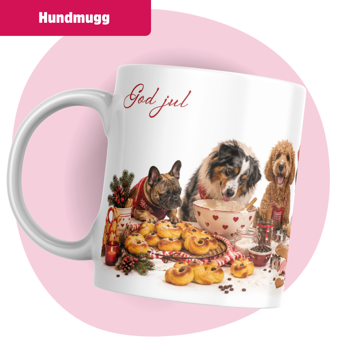 Vit keramikmugg med texten "God jul" i röd skrivstil samt ett juligt motiv med hundar som samlats runt ett bakbord fyllt med nygräddade lussebullar, en skål med smet och juldekorationer.